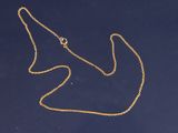 une image représentant un collier en or sur un fond bleu