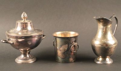 trois vases en argent posés l'un à côté de l'autre sur une table