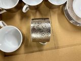 many cups and saucers sitting on a table