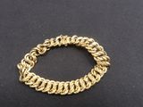 a close up of a gold bracelet on a black surface