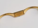 a close up of a gold watch on a white surface