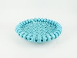 a close up of a small blue bowl on a white surface