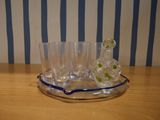 four glasses and a decanter on a tray on a table