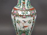 a vase with a bird and flowers on it