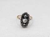 a close up of a black and white diamond ring on a white surface