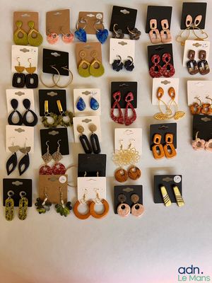 de nombreuses paires de boucles d'oreilles accrochées ensemble au mur