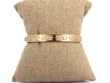 un gros plan sur un oreiller sur lequel repose un bracelet en or