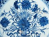 a blue and white plate with a flower design on it
