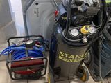 un petit compresseur d'air posé à côté d'une pile d'autres équipements