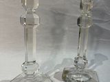 deux bougeoirs en verre transparent posés sur une table