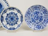 three blue and white plates with designs on them on a white surface