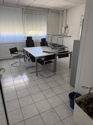 une pièce équipée d'un bureau, de chaises et d'une poubelle