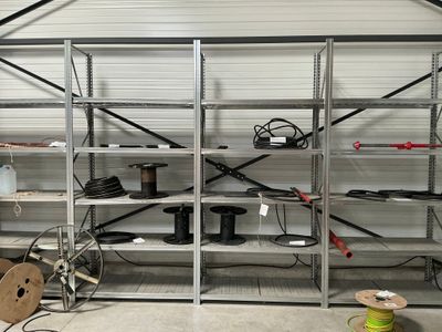 un garage où les étagères sont encombrées de câbles et de fils