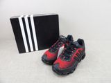 a pair of red and black running shoes next to a black box