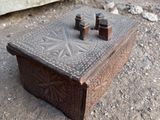 a small wooden box sitting on the ground in front of a wall