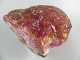 a piece of meat on a white plate with a fork