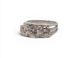 une image représentant une bague en diamant à trois pierres sur fond blanc