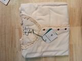a white blanket that has a tag attached to it