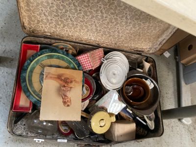 une valise remplie d'objets posée par terre