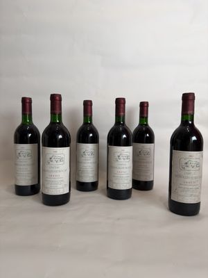 six bottles of wine are lined up in a row on a table