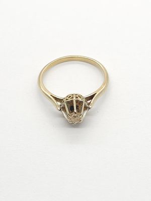 a close up of a gold ring on a white surface
