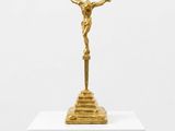 a gold statue of jesus on a pedestal with a white background