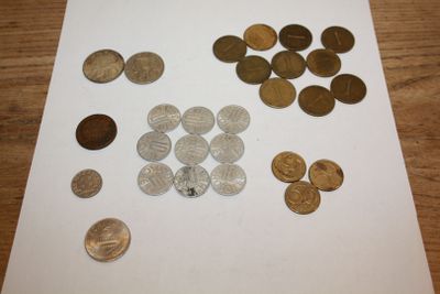 a lot of coins sitting on a table next to a piece of paper