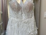 wedding dress hanging on a hanger in front of a mirror