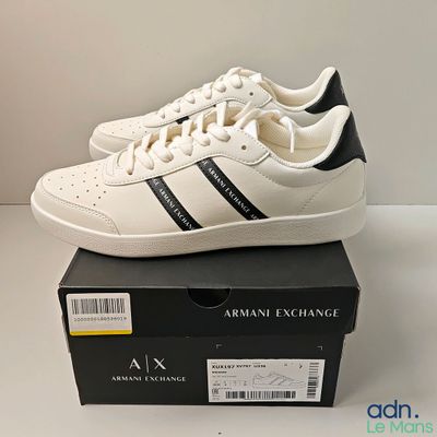 an image of a pair of white and black sneakers on top of a box