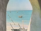 a picture of a picture of a beach with a boat in the water