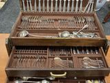 beaucoup d'argenterie dans un coffret en bois posé sur une table