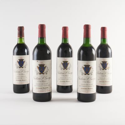 quatre bouteilles de vin sont alignées sur une surface blanche