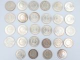 an assortment of silver and silver coins on a white surface