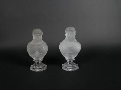 two clear glass vases sitting on top of a black surface