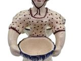 a ceramic figurine of a woman holding a bowl