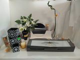 une table sur laquelle se trouvent un miroir, un vase, une bougie et des fleurs