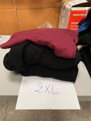 une pile de vêtements posée sur une table, avec une étiquette de prix