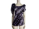 Le mannequin porte une robe à imprimé léopard violette et noire.