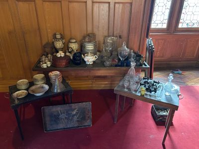 une table sur laquelle sont disposés de nombreux objets, dans une pièce aux murs lambrissés