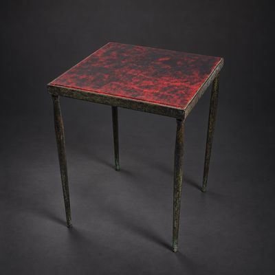 une image représentant une petite table au plateau rouge sur fond noir