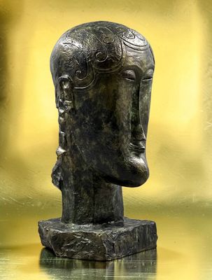 statue représentant la tête d'un homme posée sur un rocher dans un étang