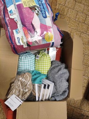 une boîte en carton posée par terre et remplie d'objets divers