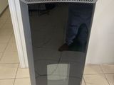un purificateur d'air noir posé au sol dans une pièce