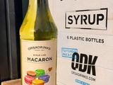 a bottle of macaron sitting on a table next to a box of drinks