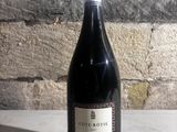 a bottle of wine sitting on a table next to a brick wall