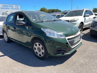 a green car parked in a lot with other cars in the background