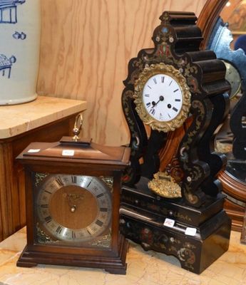 une horloge posée sur une table à côté d'un vase