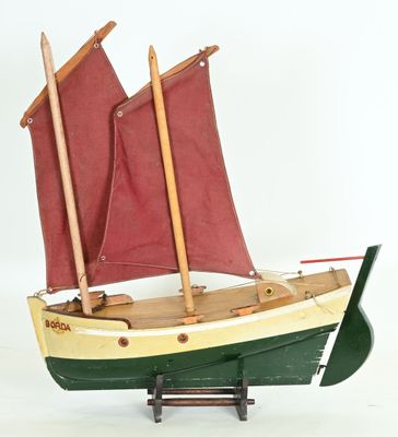 a model of a boat with red sails on a stand