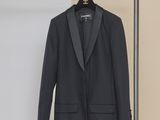 une veste de smoking noire suspendue à un cintre dans une pièce