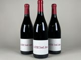 trois bouteilles de vin rouge posées sur une table